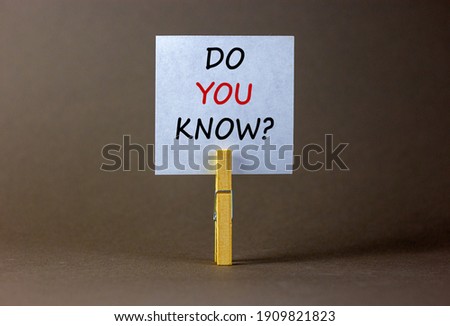 Do you know symbol. White paper with words 'do you know', clip on wood clothespin. Beautiful grey background. Business, support and do you know concept, copy space.