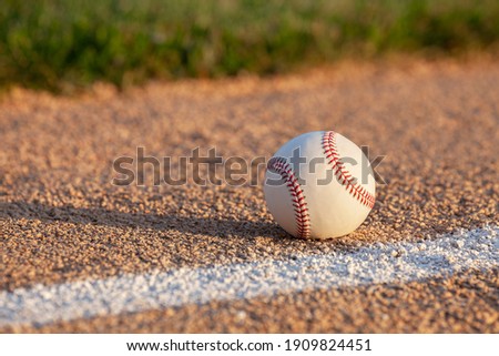 Low angle selective focus view of a baseball on a basepath with a white stripe