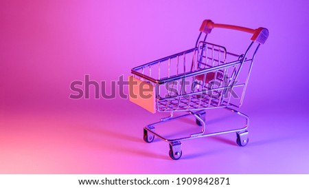 Shoping trolley with in trendy neon light. Gradient pink-blue glow. Concept art. Retro 80s. Minimalism shopping concept. Toy shopping trolley, neon Royalty-Free Stock Photo #1909842871