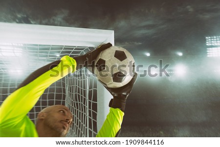 Close up of a soccer goalkeeper saving the ball at the corner of the goalposts Royalty-Free Stock Photo #1909844116