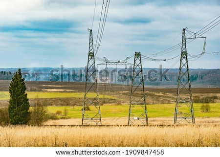 High-voltage towers on the cloudy sky background.