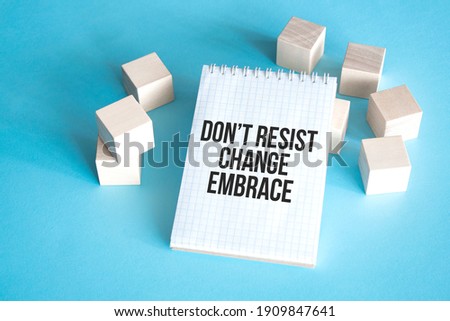 Text Dont resist change embrace on white notepad with cube block, stock concept.