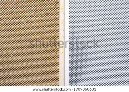 cleaning dirty clogged range hood filter from domestic kitchen. dirty and new clean filter. above view. Royalty-Free Stock Photo #1909860601