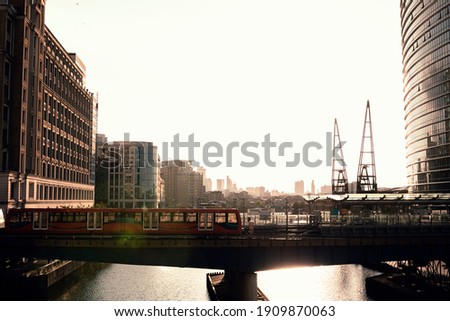Stock photo taken of a train traveling at dusk in a London dock area at dusk