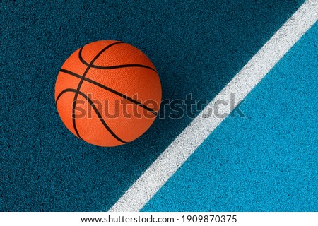Orange basketball on blue court of gymnasium sport floor. Team sport concept