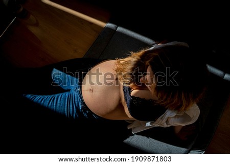 pregnant woman in the twilight and with a light focusing on her tummy