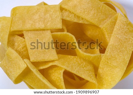 A very closeup shot of pappardelle on a white background	