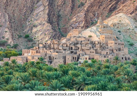 Middle East, Arabian Peninsula, Oman, Ad Dakhiliyah, Nizwa. Palm trees and a traditional mountain village in Nizwa,Oman. Royalty-Free Stock Photo #1909956961