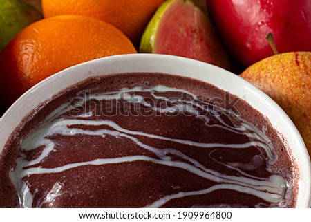 Acai (Açai) with Doomed Milk, Brazilian Tradicional Fruit with Tropical Fruits on a Bowl on  Wooden Table 