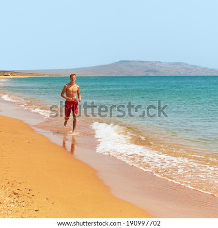 Man running in water on the beach. jogging along the coastline. outdoor sports