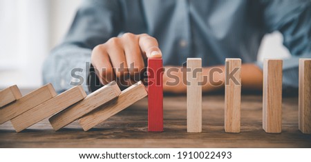 close-up hand The hand of a businessman who is stopping or preventing a falling block.Risk protection concept,Eliminating the risk Royalty-Free Stock Photo #1910022493