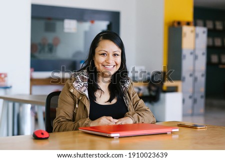 latin woman portrait, mexican girl looking to camera in office in Mexico city Royalty-Free Stock Photo #1910023639