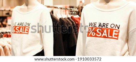 T-shirt with advertising text ‘we are on sale’ on mannequins in a clothing store. Retail shopping. Banner.