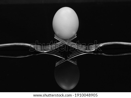                          egg on two forks on black background      