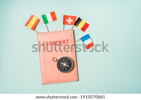 Travel concept passport from which the flags of different European countries stick out. The opportunity to travel to the countries of the Schengen Union.