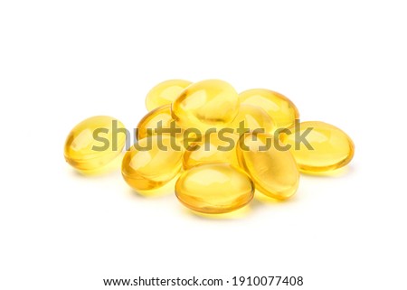 Pile of golden color oil in soft gel capsule isolated on white background. Royalty-Free Stock Photo #1910077408