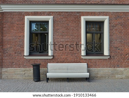 Red brick wall and white bench