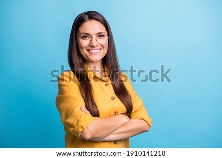 Photo of charming positive person toothy smile folded arms look camera isolated on blue color background