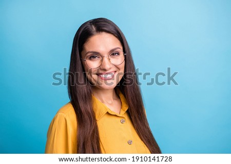 Photo of half turned satisfied person look camera beaming smile eyewear isolated on blue color background