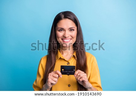 Photo portrait of business woman smiling holding debit plastic card isolated on vibrant blue color background
