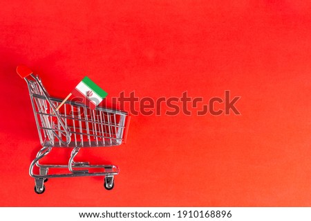 Shopping cart and Iran flag on red background. Shopping online or eCommerce, delivery service store