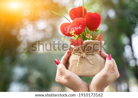Woman holding a heart shaped bouquet of flowers for the day of love