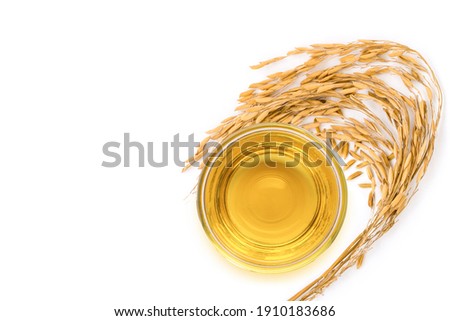 Rice bran oil extract with paddy unmilled rice on white background. Top view. Flat lay. Royalty-Free Stock Photo #1910183686