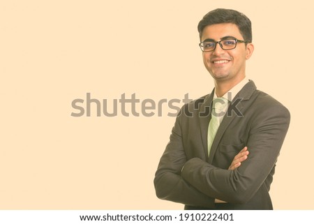 Portrait of happy young handsome Persian businessman with eyeglasses