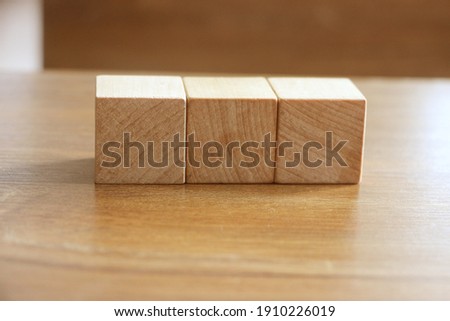 3 Wood Blocks Front View, On Wooden Table, polished wooden table background.