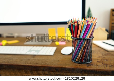 Colored pencils placed in front of the desk at home 