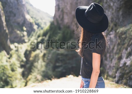 Young european female tourist with black hat watching Devil's Throat Cave, Bulgaria 