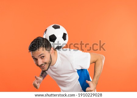Young Man football soccer player balancing soccer ball on the back of neck and giving thumbs up