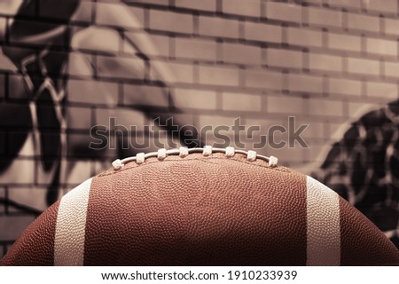 American leather football ball on brick wall background