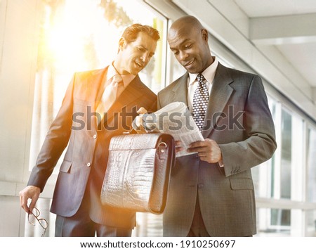 Portrait of businessman showing business plan to colleague