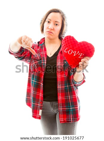 Young woman holding heart shape and showing thumbs down sign