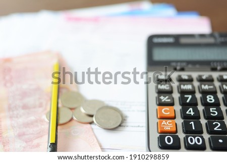 No Focus, a picture, a calculator and money placed on a document with a pencil next to it.