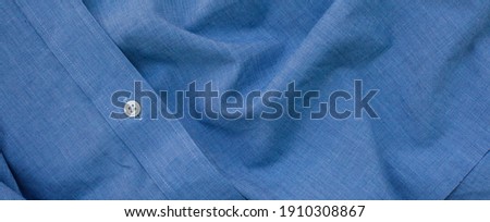 Blue linen background with white buttons on the collar.