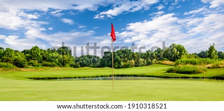 Putting green with a flag at a golf course on a summer day Royalty-Free Stock Photo #1910318521
