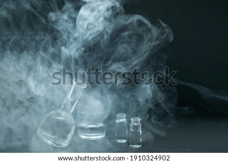 Glassware, flasks, vials for experiments or chemical experiments on a black background. Work on the invention of a vaccine or a new drug. Selective focus, blurred image.