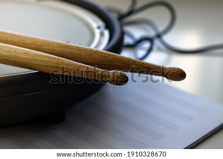 Drum sticks made of wood and a pad from an electronic drum kit close-up. Music hobby concept. Home art hobbies authentic concept. Musical hobby drums