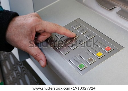 Close-up of someone making their secret code on the keypad of an ATM  Royalty-Free Stock Photo #1910329924