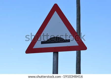 Photo of a warning sign for a speed hump against a blue sky Royalty-Free Stock Photo #1910348416