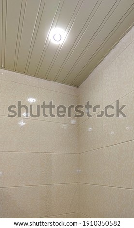 The interior of the bathroom after the renovation. Wall tiles and slatted ceiling in soft beige tones. Royalty-Free Stock Photo #1910350582