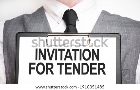 Businessman holding sheet of paper with a message INVITATION FOR TENDER