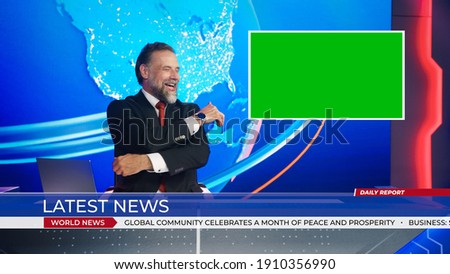 Live News Studio with Charismatic Male Newscaster Uses Green Chroma Key Screen Placeholder Copy Space. Anchorman Having Fun and Laughing. Mock-up TV Newsroom Set with News Ticker.