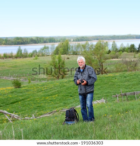 Elderly travel photographer on the nature