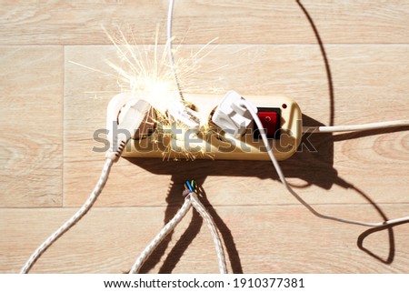 The photo shows the extension cord lying on the floor with a large current consumption. The concept of large energy consumption, dangerous fire Royalty-Free Stock Photo #1910377381