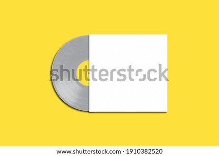 Gray vinyl long play record with white cover on a yellow background. Modern phonograph record concept