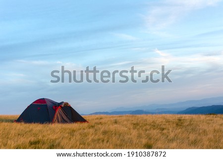 The tent against the blue gloomy sky. Bright and rich colors. Fall. Camping and outdoor recreation. Carpathian mountains Royalty-Free Stock Photo #1910387872