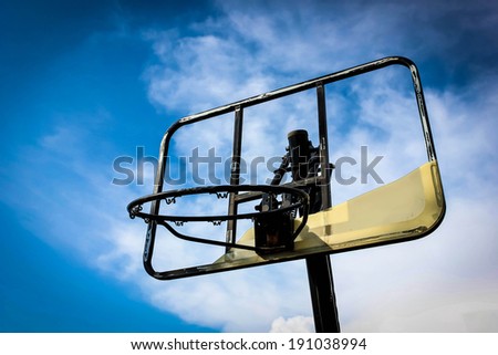 The old basketball hoop under the blue sky.